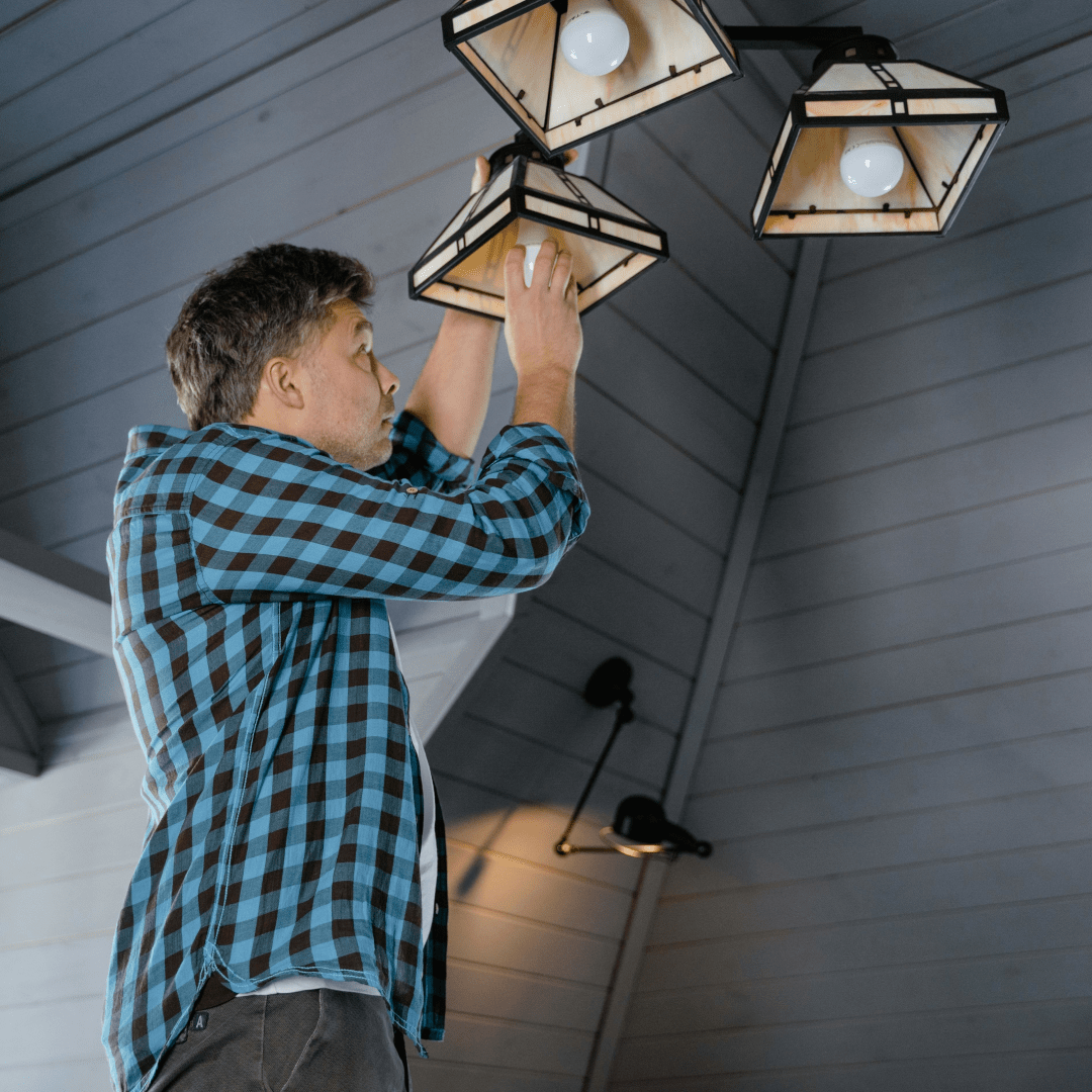 Man installing lightbulbs into new light fixtures